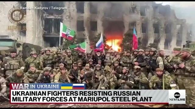 Chechen unit fighting with Russia stands before a burning building and claims it has “cleansed and destroyed” Mariupol.