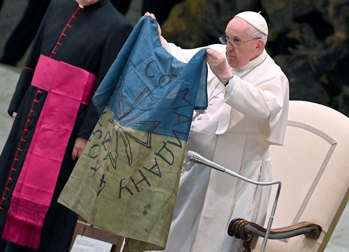 Pope Francis condemns ‘massacre of Bucha’ and kisses Ukrainian flag