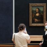 Man in wig throws cake at glass protecting Mona Lisa